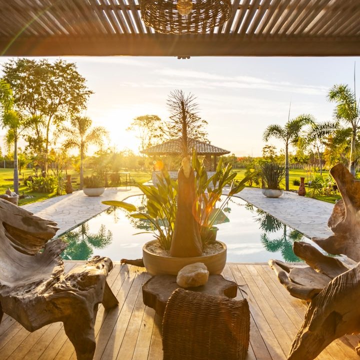 Women’s Leadership Retreat Costa Rica Sunlit patio with pool, tropical plants, and wooden furniture.